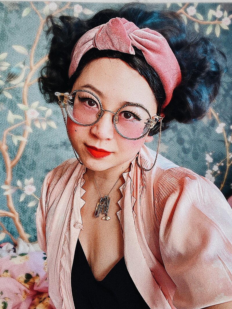 Esmé Weijun Wang, a Taiwanese American woman wearing claw glasses and lipstick, looking into the camera