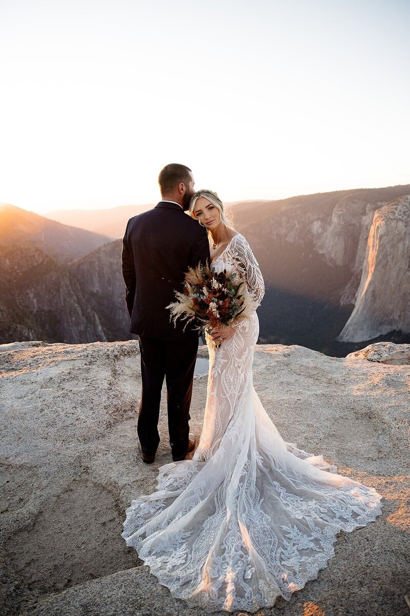 Couple cuddling for photo on top of a mountain in Yosemite.