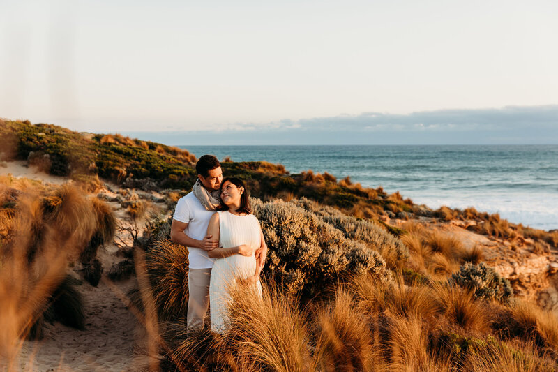 Man and pregnant woman cuddle into each other at Mornington Penisula maternity photography session