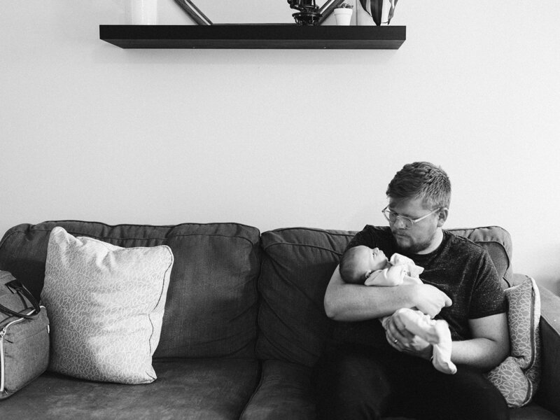 man holding baby on the couch