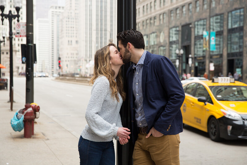 couple kissing woman gasping from surprise engagement downtown chicago mag mile