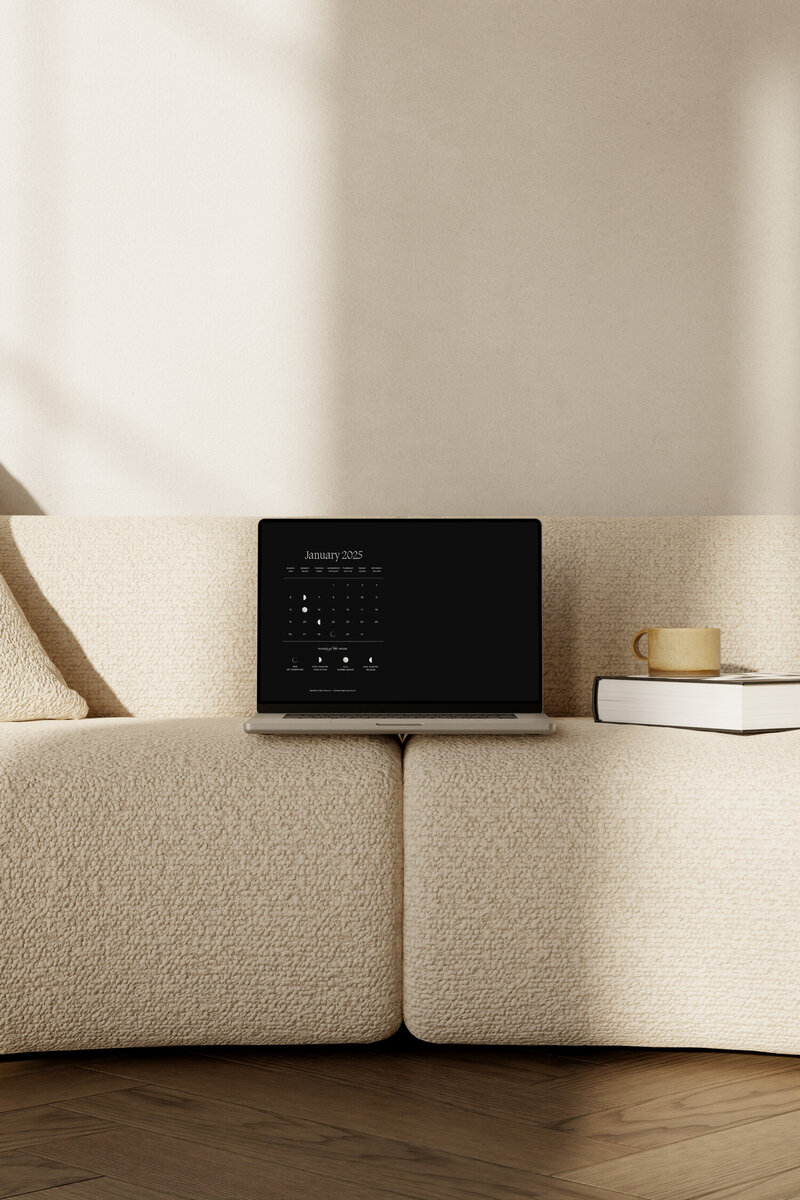 Minimalist moon calendar desktop wallpaper mocked up on a laptop.