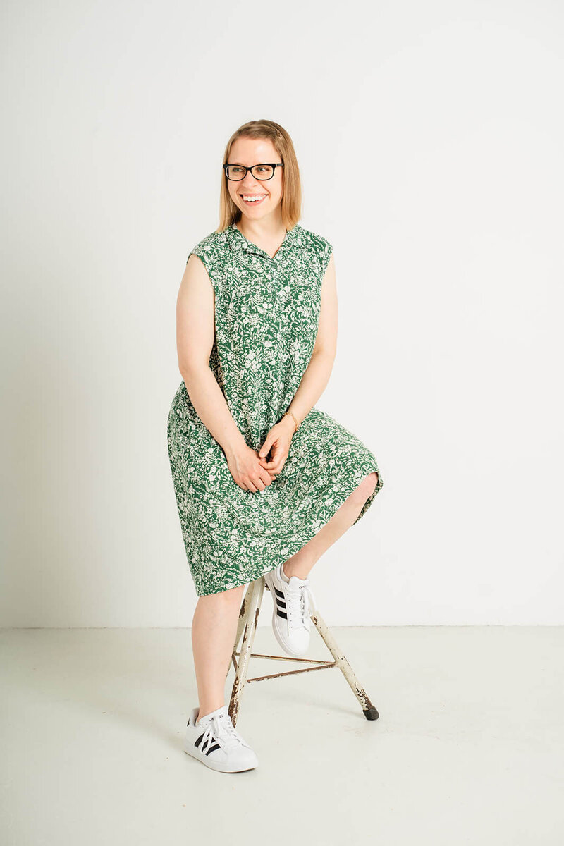 Stephanie Pampel, an American accent and English communication coach for international professionals, sits on a stool.