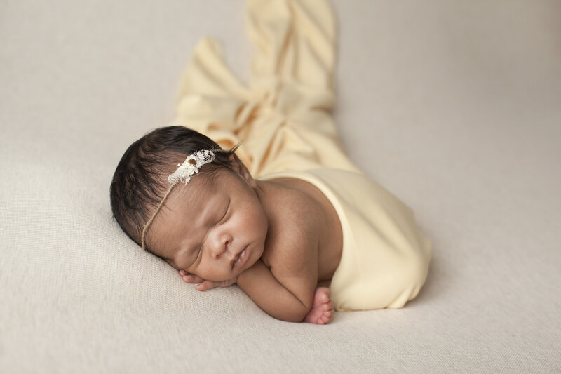 newborn girl wrapped in yellow