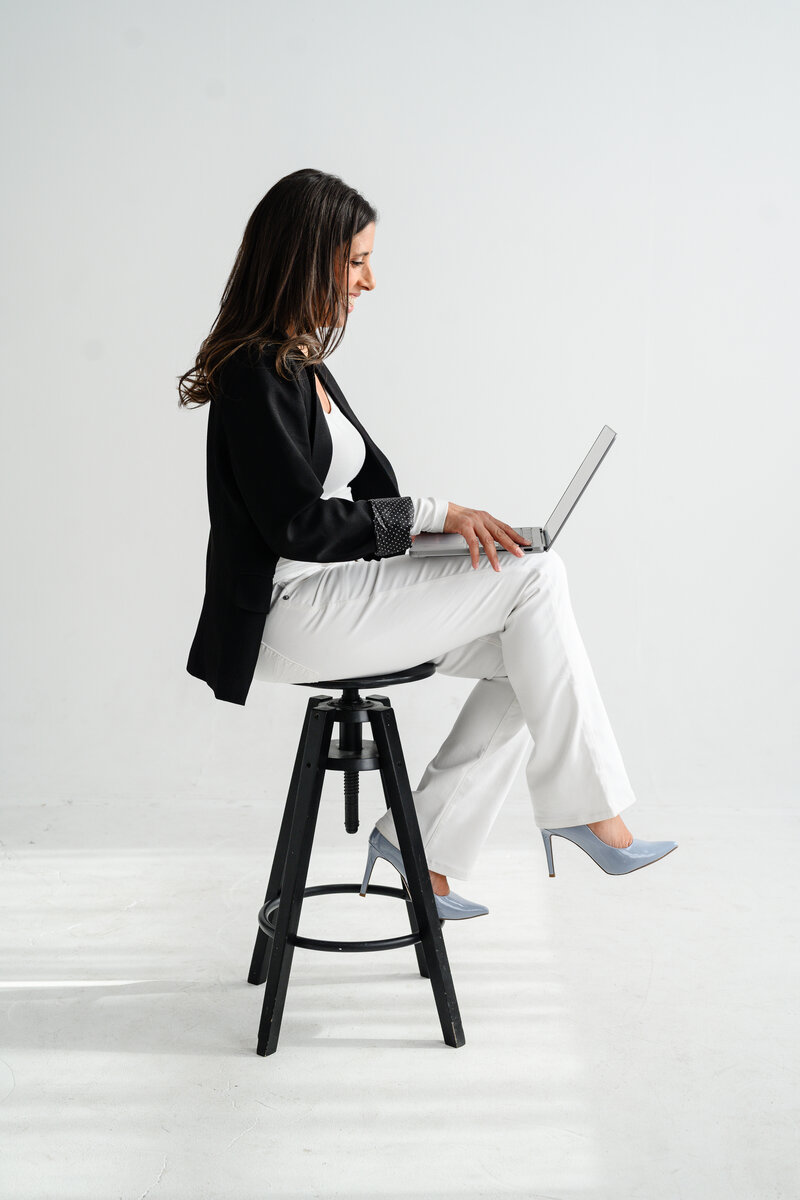 Jo, founder of Branding by Jo, sits with a cup in her Orlando studio, blending professionalism and relaxation in her branding approach.