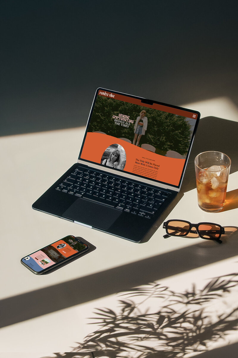 A poster depicting an elopement photographer website homepage resting on a deep sienna colored leather couch