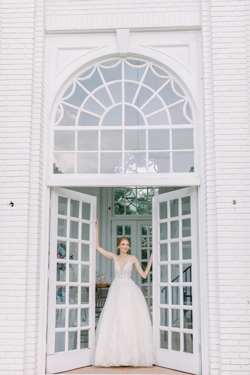 A bride opens the doors at Butterfield Mansion.