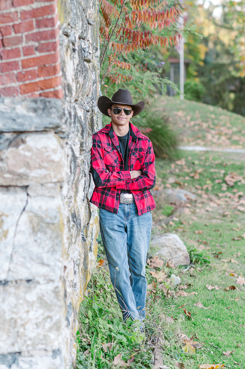 Senior boy, leaning up against a stone wall by York PA photographer