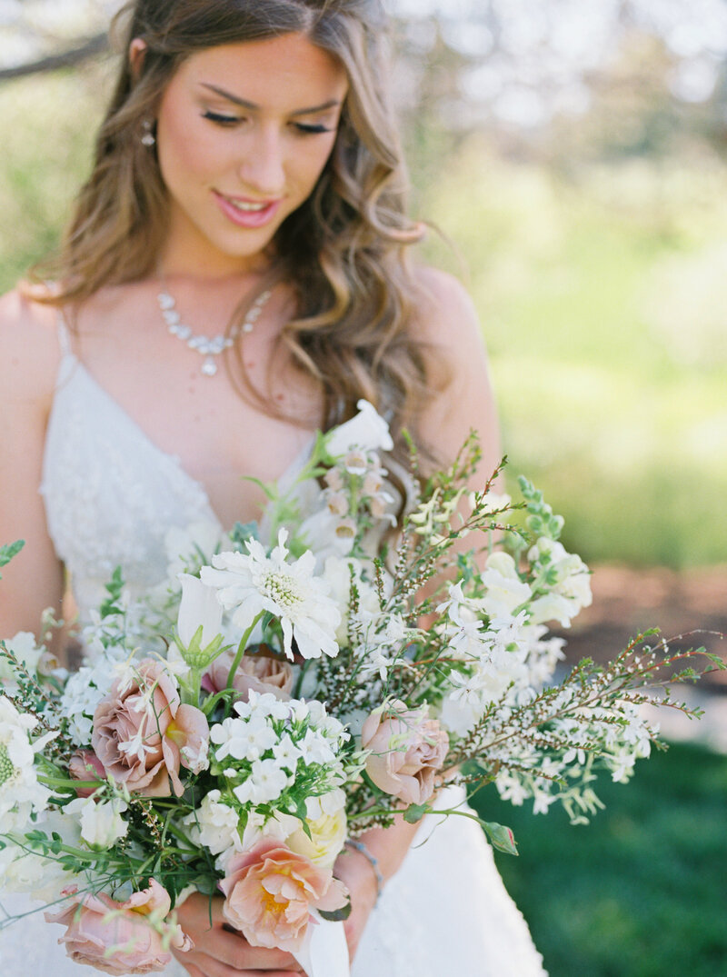 Madison gazing softly at her bridal bouquet