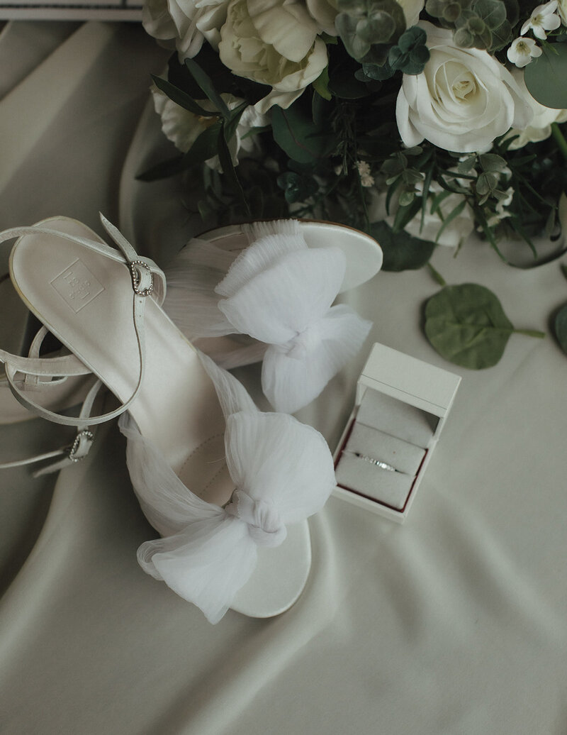 Bride's wedding heels and engagement ring and floral bouquet
