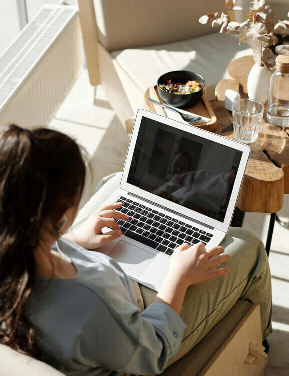 Woman who is sitting down and typing on her computer