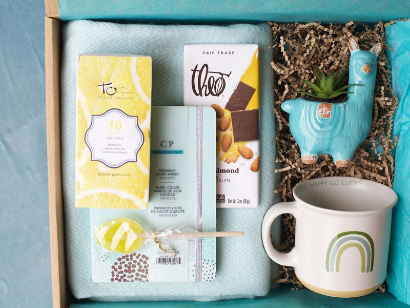 Gift basket with various items including a notebook, coffee mug and chocolate, representing a possible raffle item for a silent auction fundraising event.