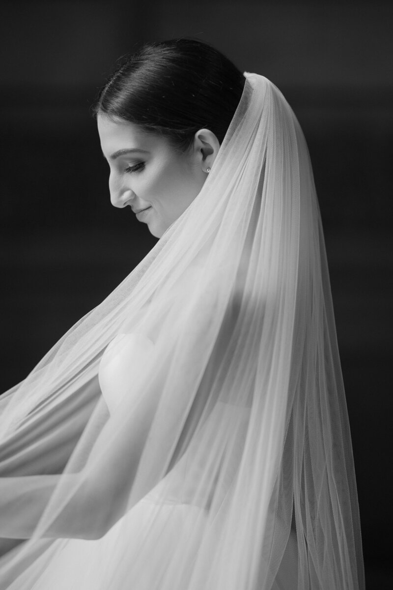 A black and white cinematic portrait of a dark skin tones bride with long wavy hair on her wedding in New Jersey