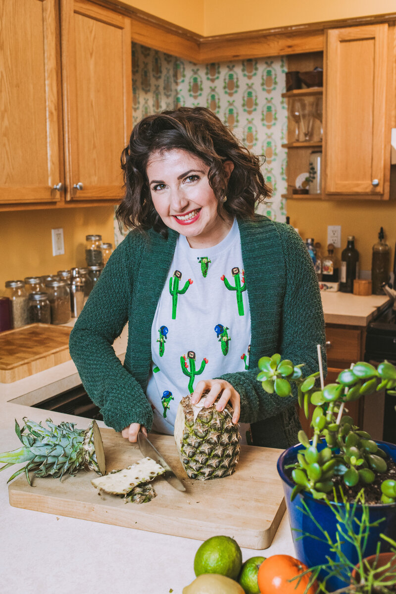 Woman slices pineapple in her kitchen