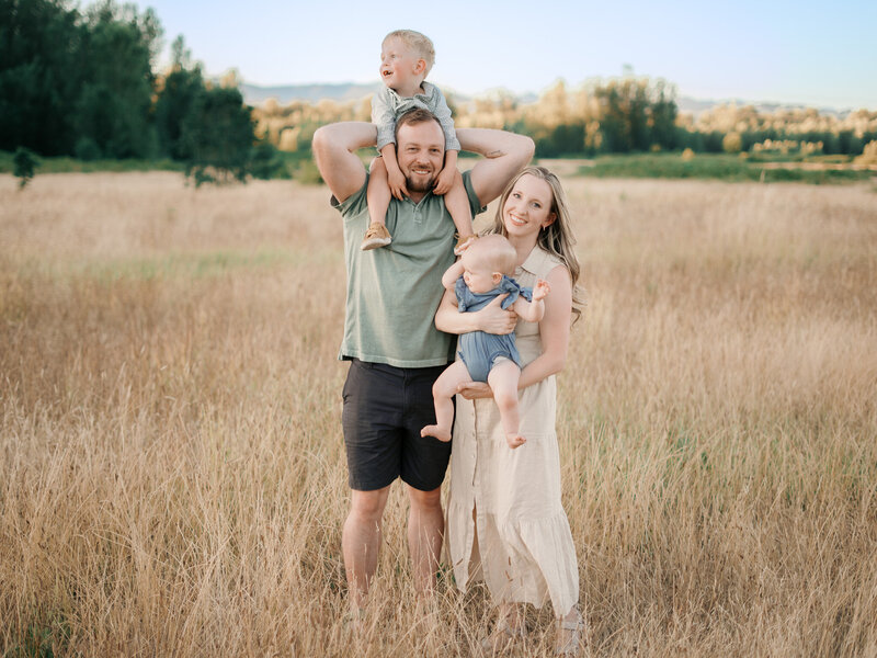 Family of 4 in field during golden hour