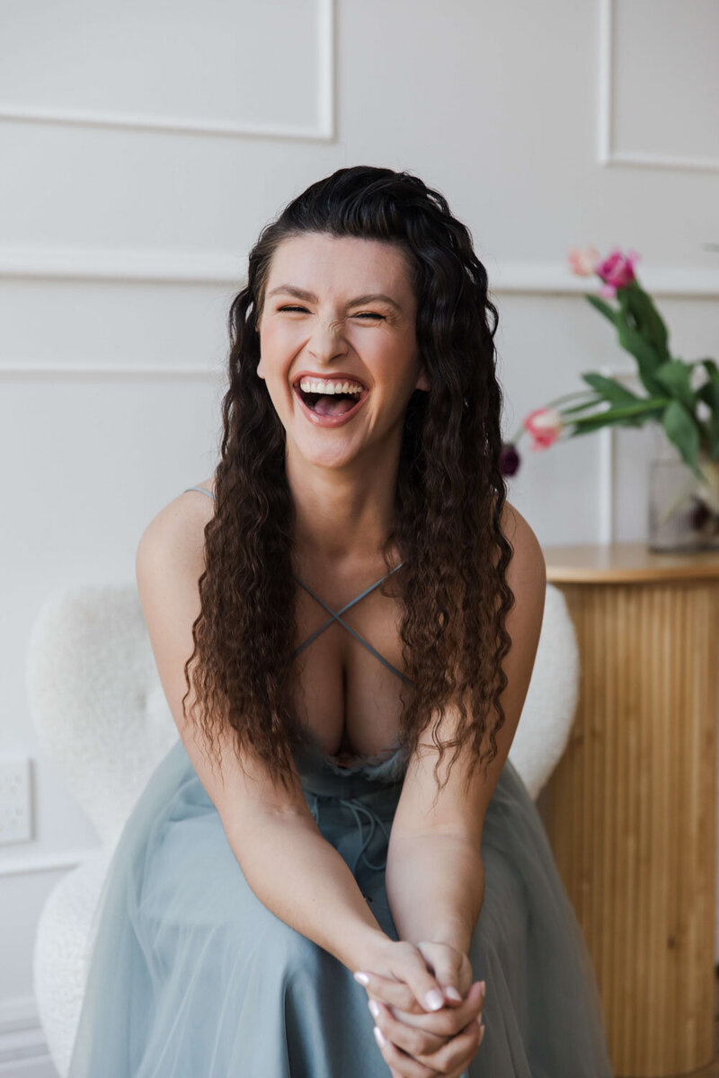 Hailey Ann, a bookkeeper for female entrepreneurs , laughing in a professional headshot