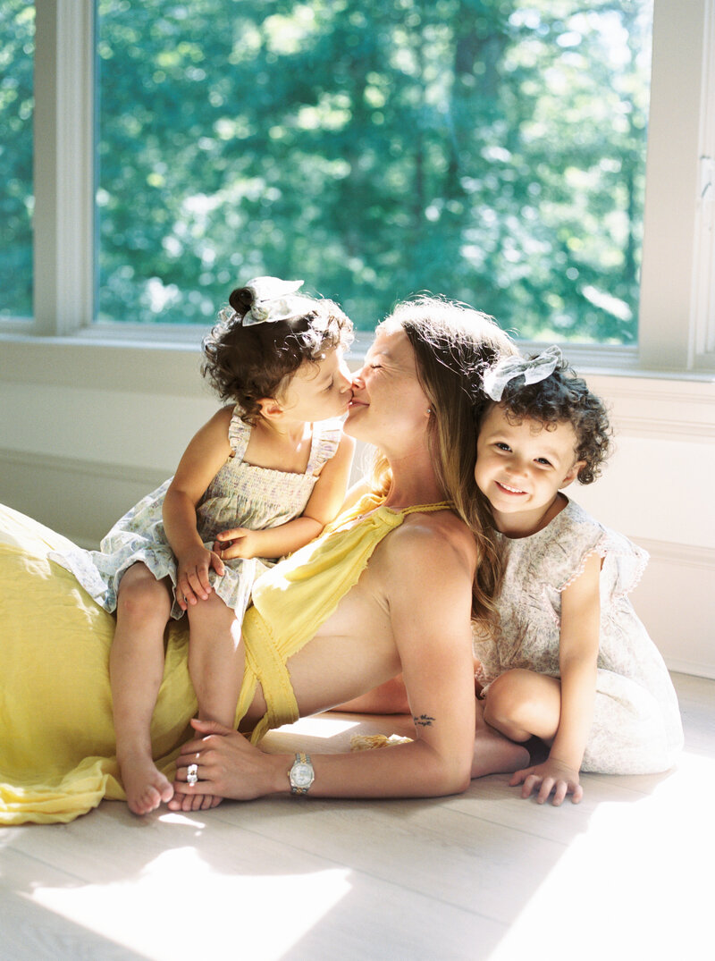 mom and daughters snuggling together during Raleigh family photos with Morgan Williams Photography