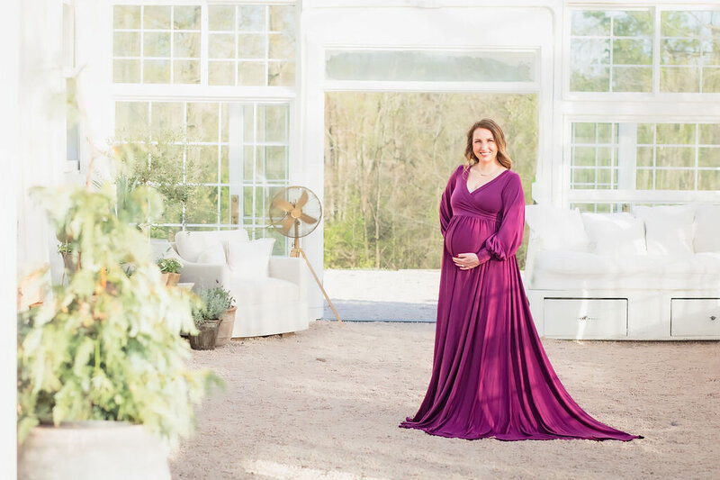 Pregnant woman cradling her belly during maternity photo session near Lake Norman