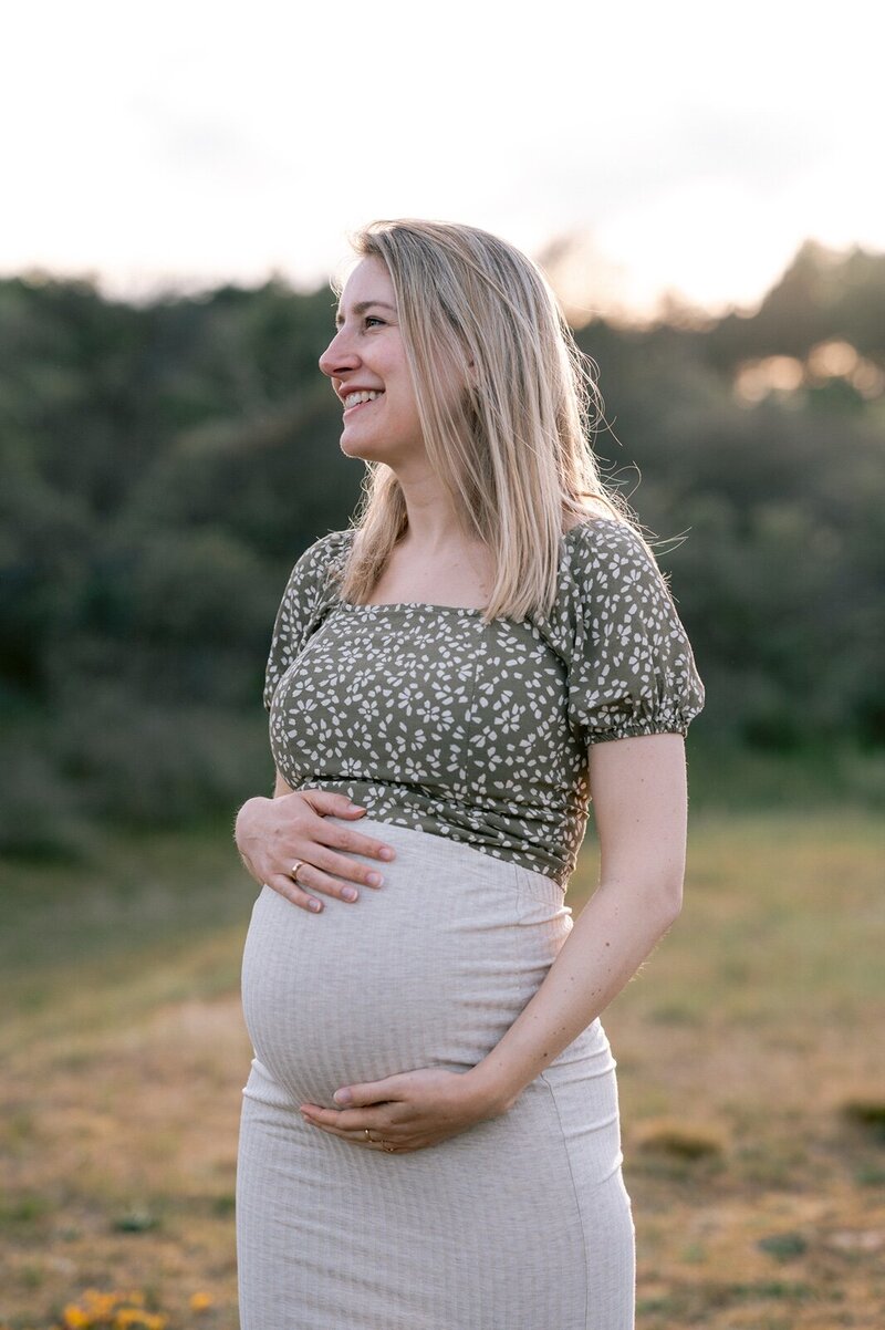 Zwangere vrouw in de duinen poseert voor zwangerschapsfotograaf Leiden