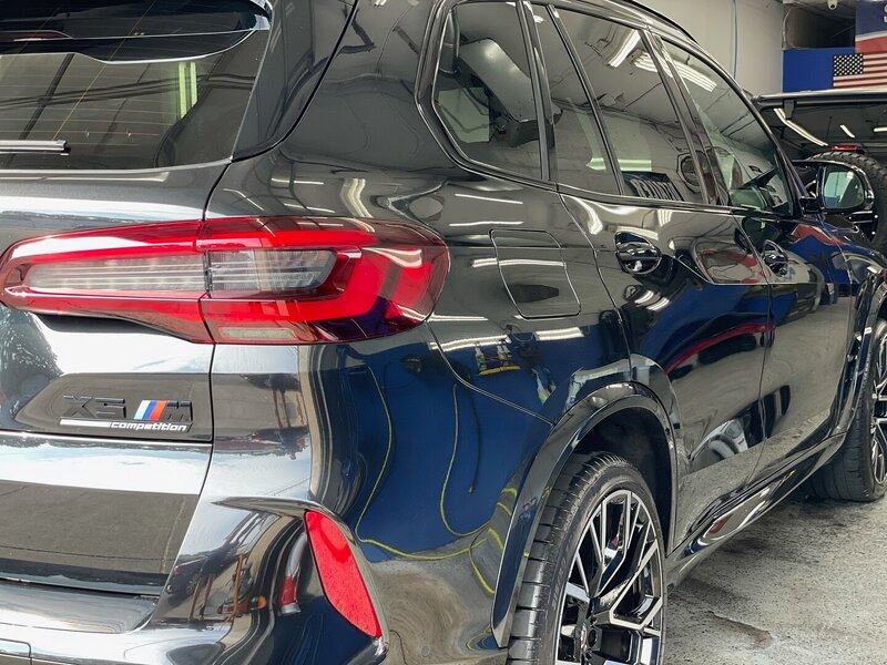 Glossy black BMW X5 M showcasing the results of a professional exterior wash and window tinting service at Superstar Auto Spa in Queens, NY