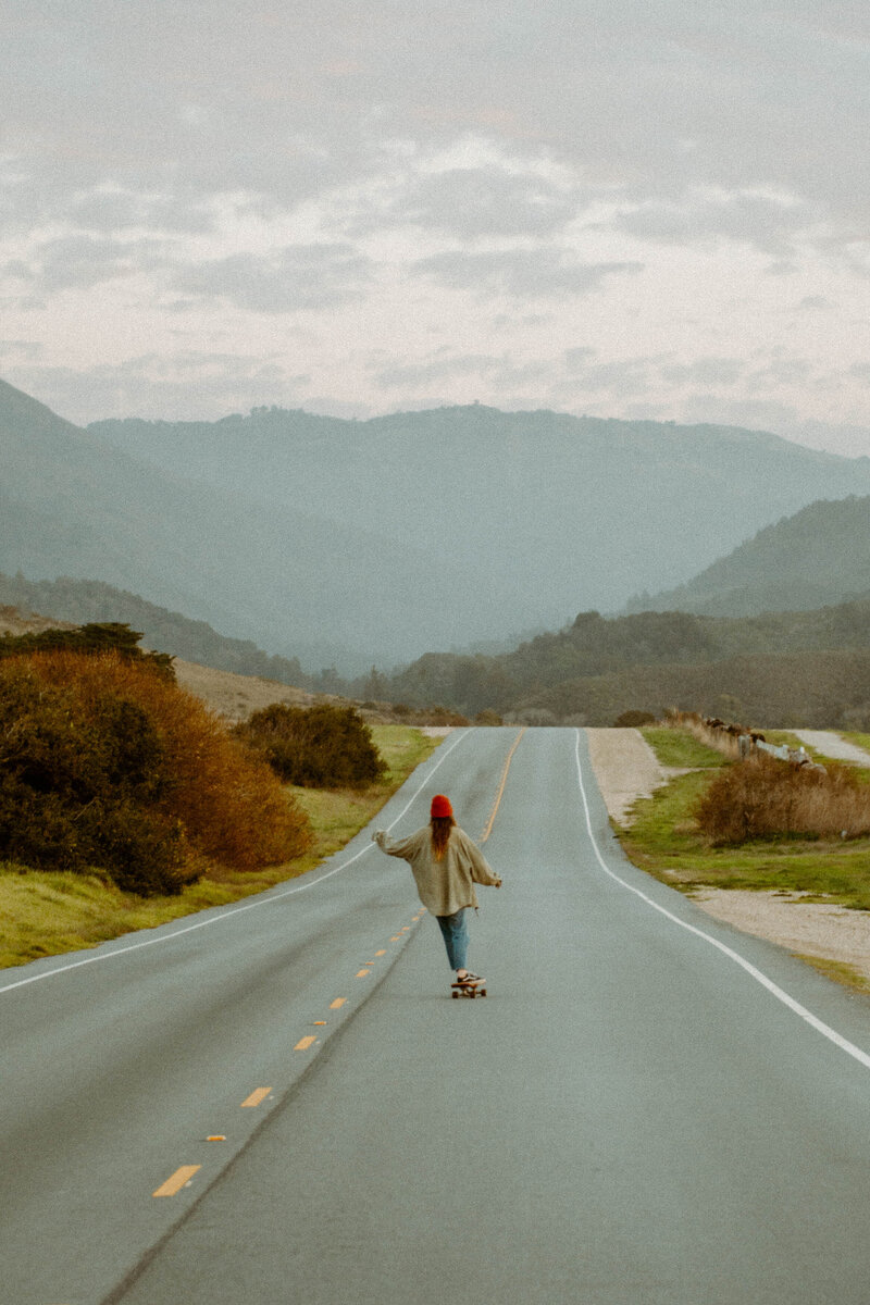 Carmel portrait of girl riding Arbor Collective Flagship Series on Highway 1 in Big Sur California