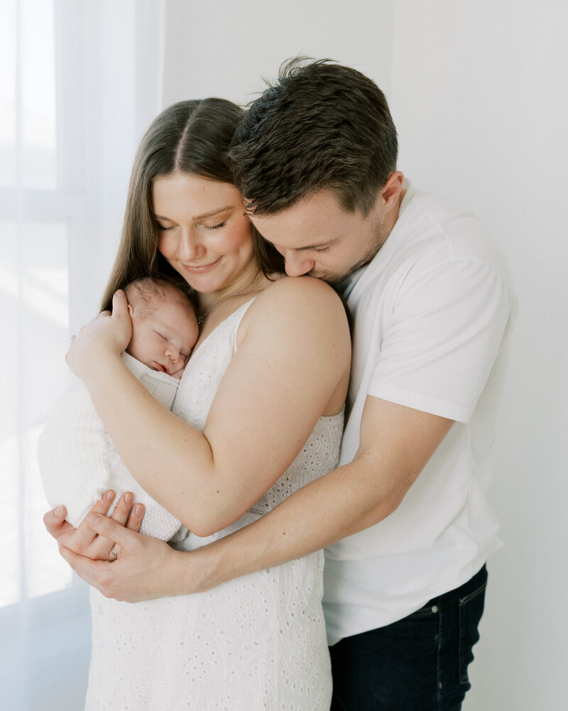 mom and dad with newborn in studio newborn  photoshoot