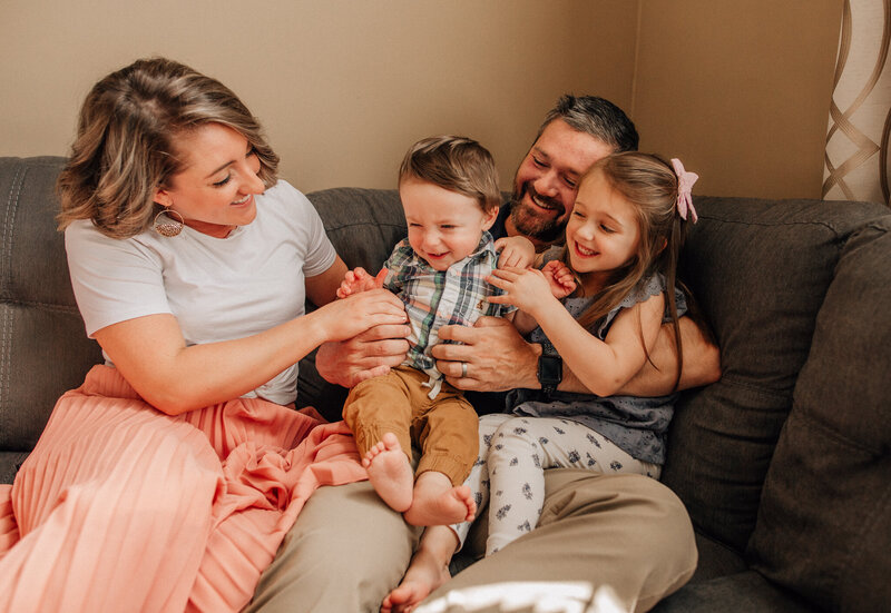 Milestone photographer capturing special moments with a mom, dad, and two young children.
