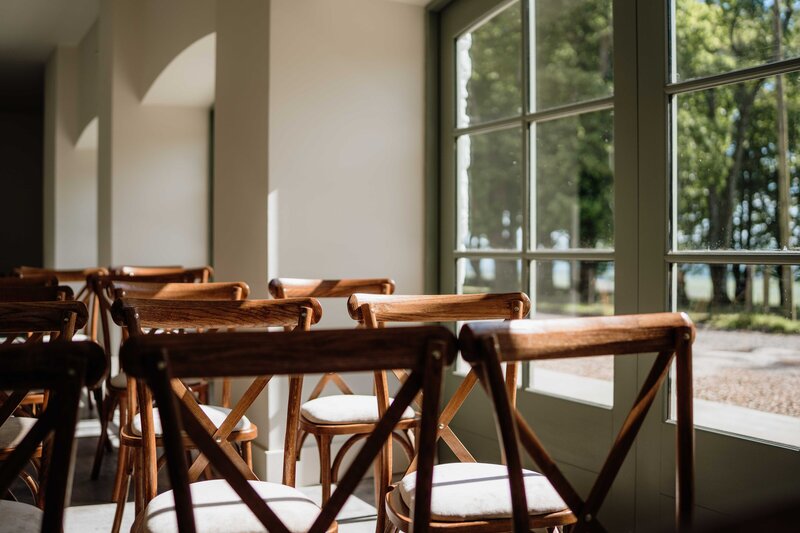 A detail photograph of a newly renovated barn space. The space is white and has concrete floors, the space is set up as a wedding venue.