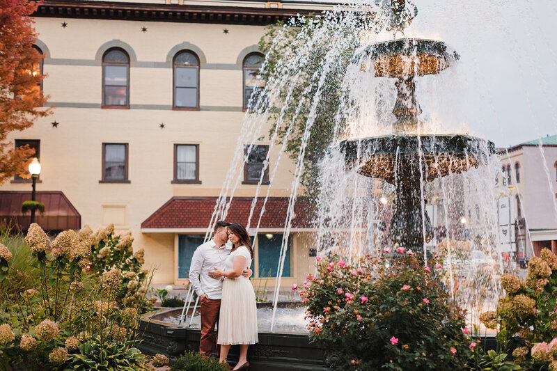 engagement couple in front of town square fountain