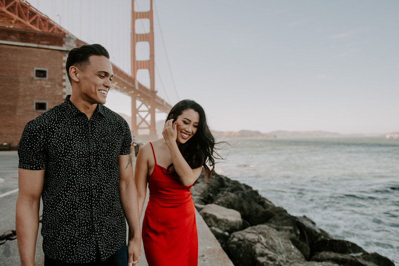 man and woman walking next to ocean