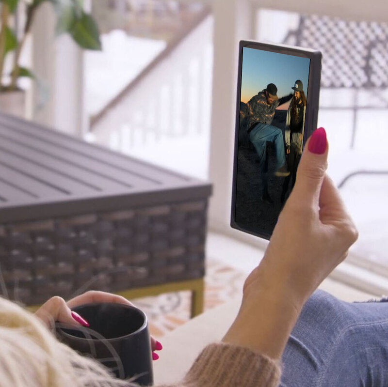 Viewing social media video on smartphone during relaxed indoor setting for content marketing