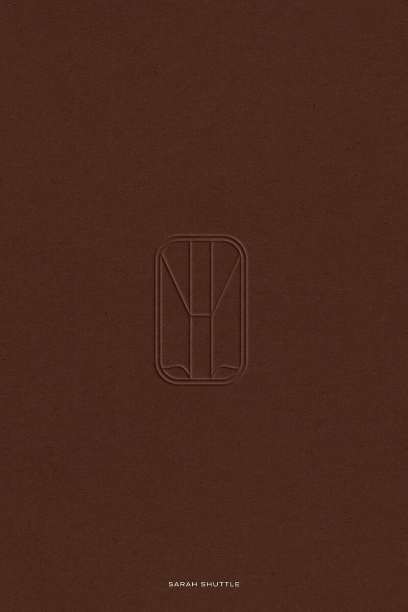 Embossed Lucent emblem on a brown textured surface, showcasing the modern, understated luxury of the brand identity.