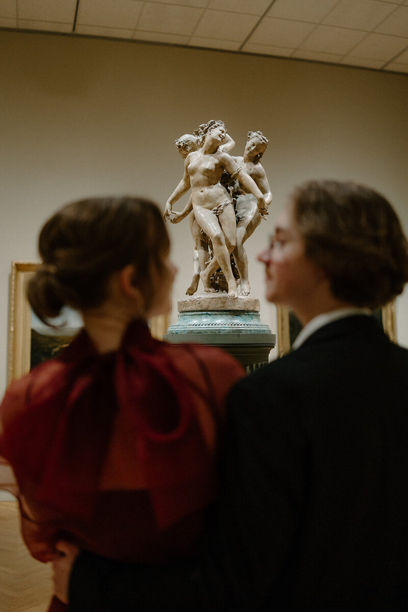 Couple exchanges a romantic glance in art museum in St. Paul engagement session