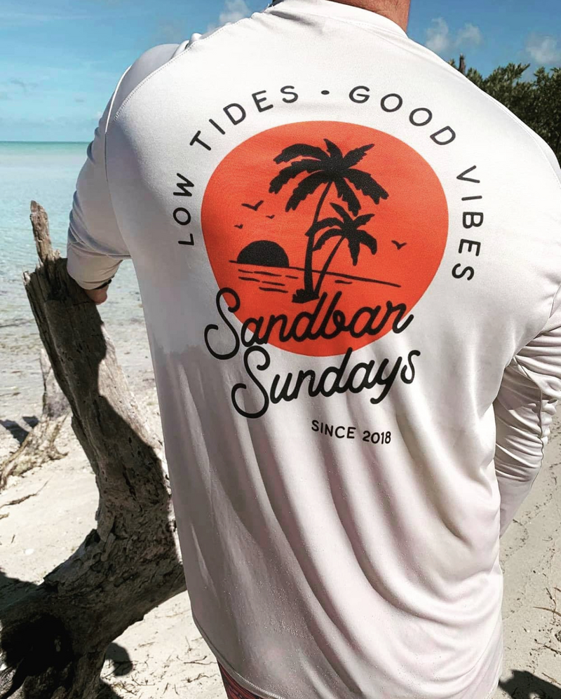 Photo of a man's back wearing a tshirt saying low tides good vibes sandbar sunday by branding bungalow key west florida