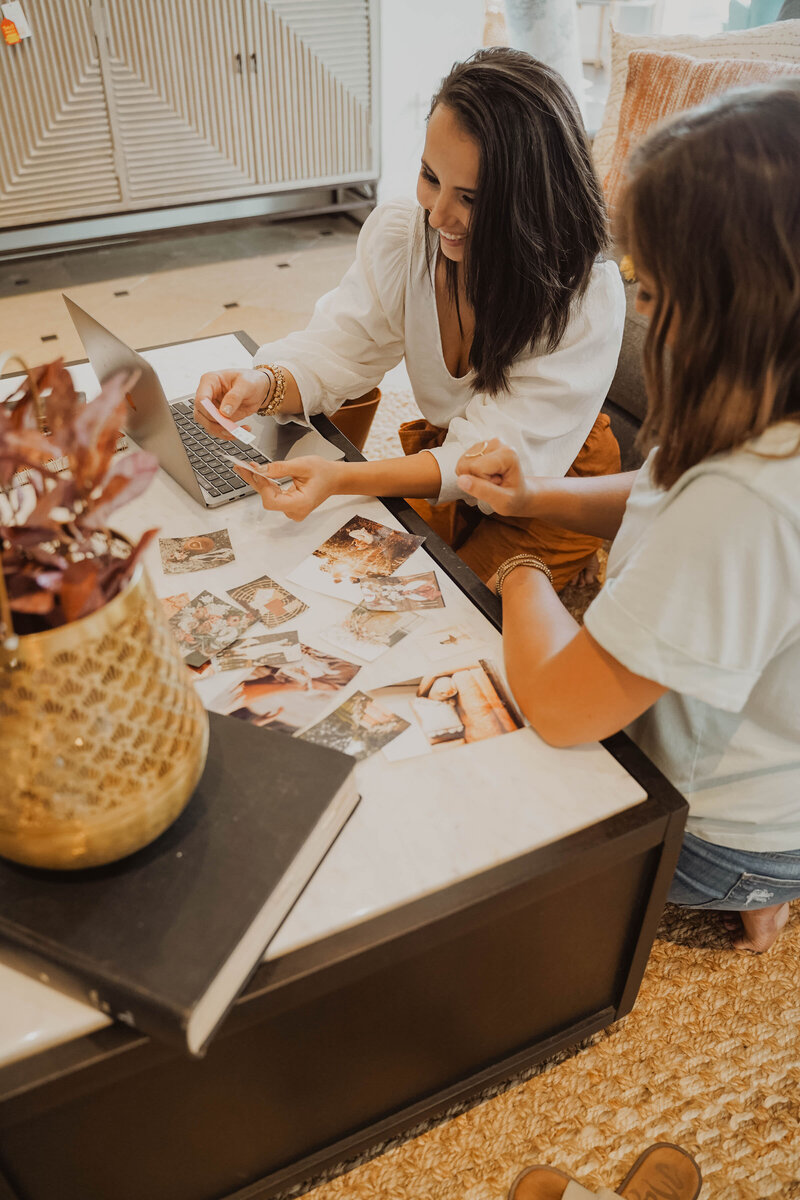 Girl holding up color palette samples sitting next to client and laptop