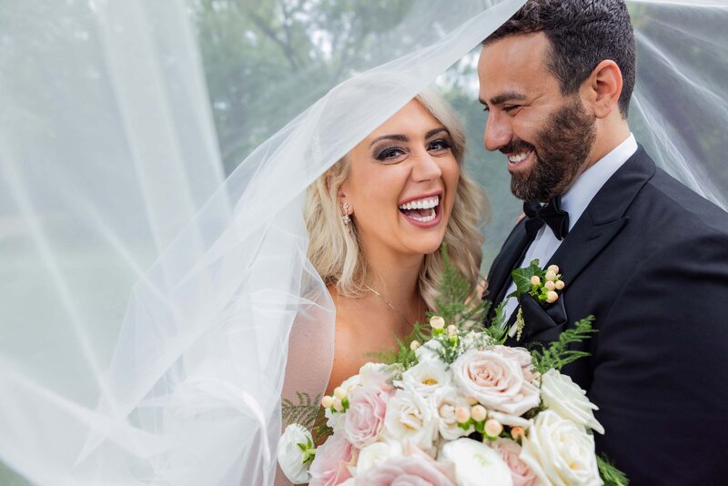 newlywed-couple-laughing-portrai-wedding-white-roses