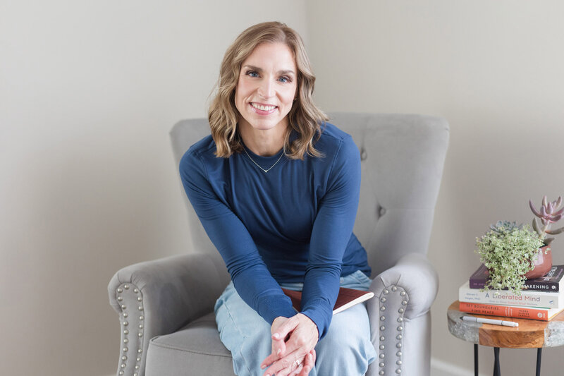 Stephanie sitting in a chair with a journal in her lap
