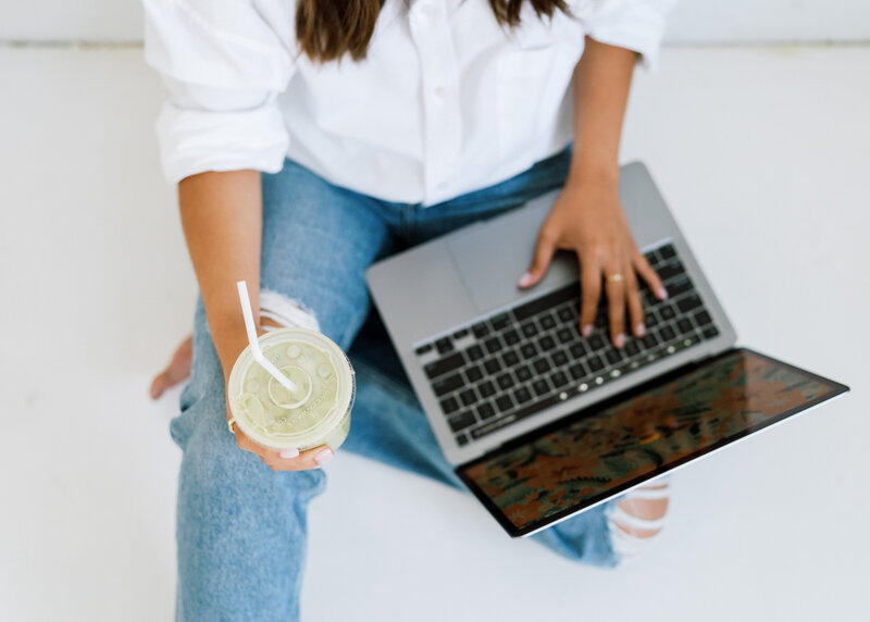 Woman working on laptop with coffee in hand