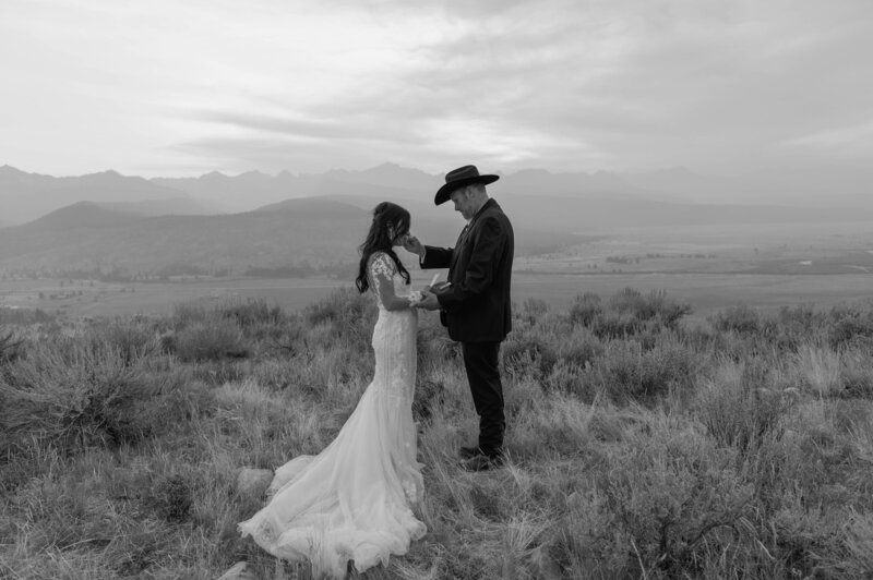 couple reading vows in the mountains