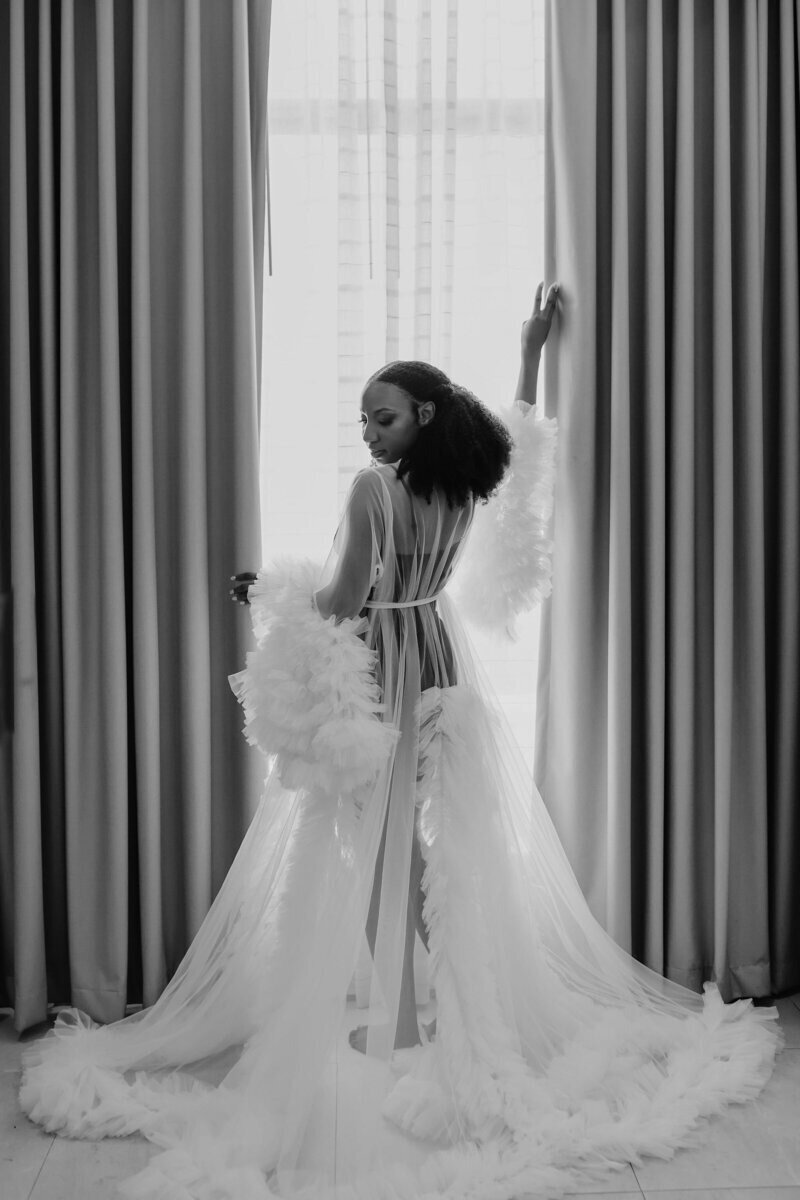 Bride near window to show reasons for using a travel agent for destination wedding