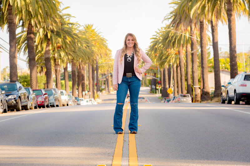 Senior Portrait standing in the road with palm trees