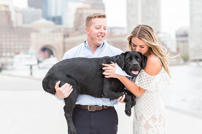 man and woman holding black lab in Boston Seaport