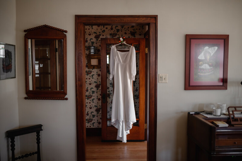 Wedding dress hangs in the entry way
