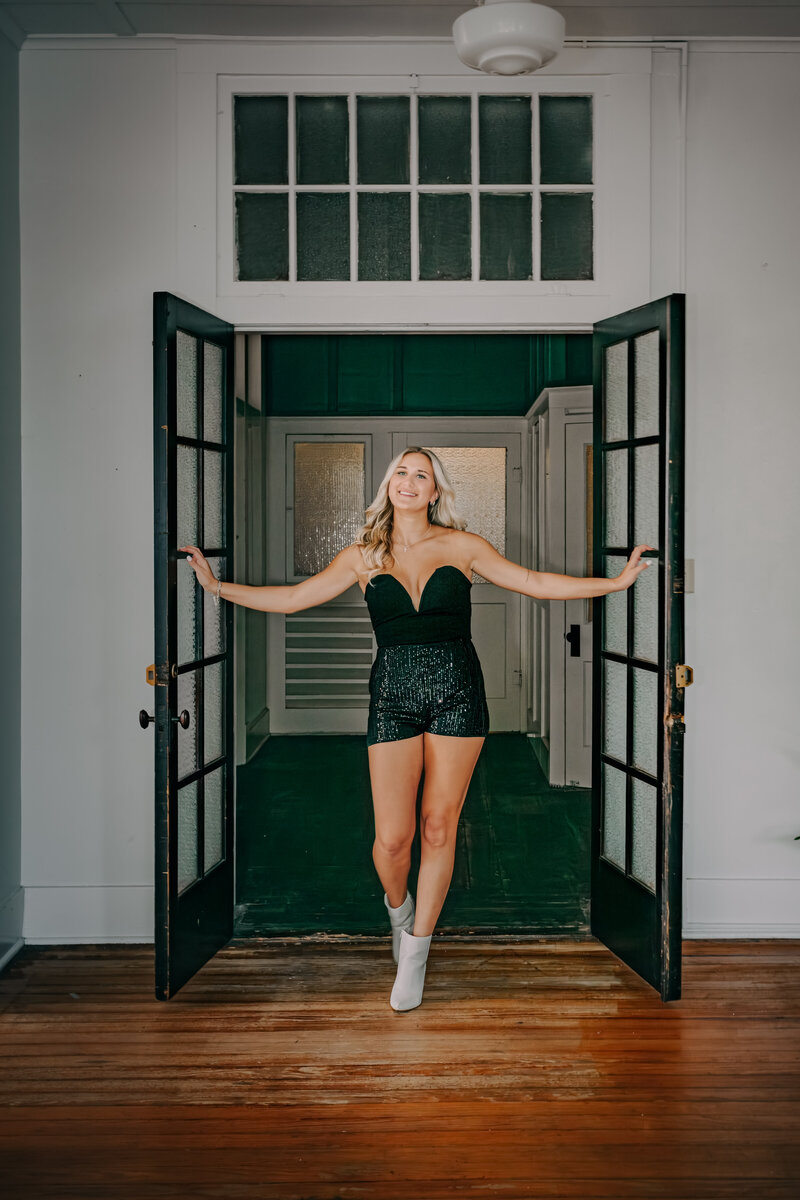 ersonal branding photo of woman in black shorts and bustier walking through studio doors in New Braunfels, fun and edgy vibe.
