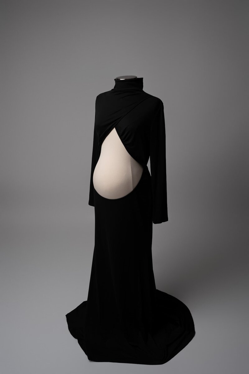 Studio image featuring a two-piece black maternity set with exposed belly