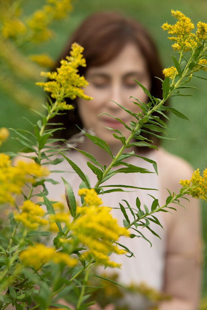 Jennifer softly  blurred out behind yellow flowers