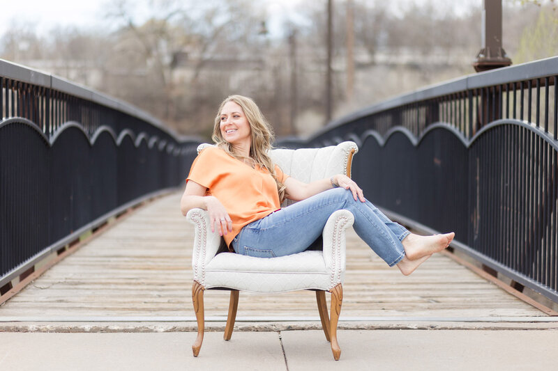 Amy smiling on a chair next to a bridge