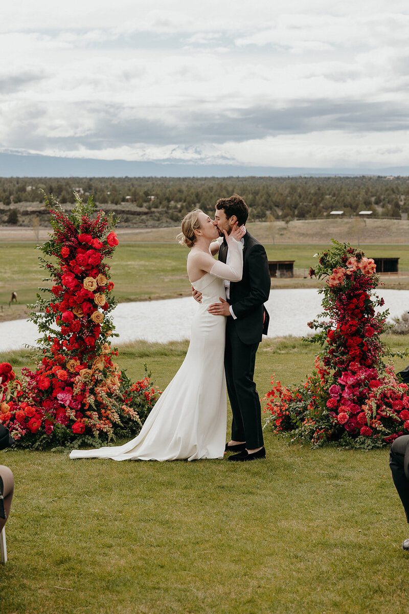 Colorful floral pillars at Brasada Ranch ceremony with mountain backdrop