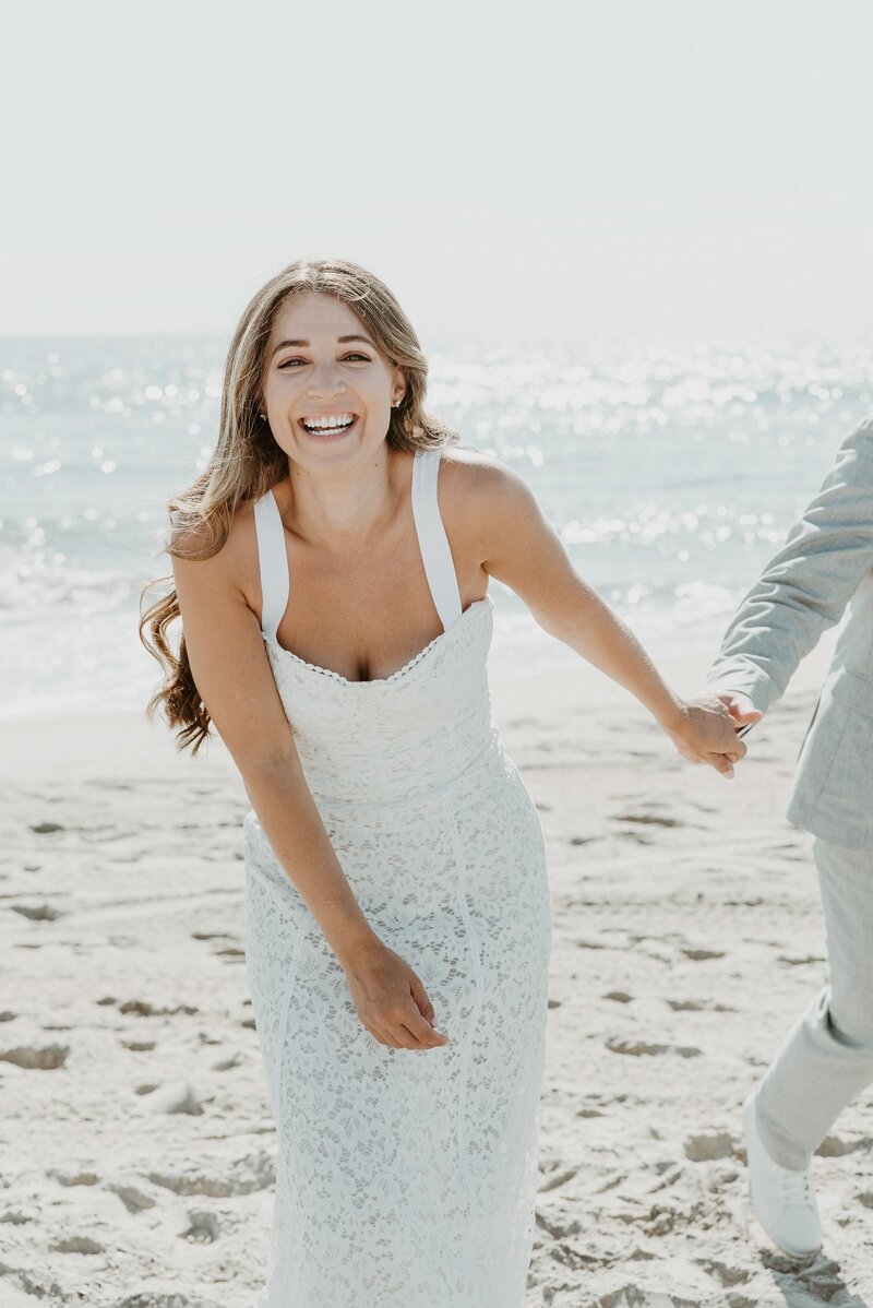 Bride smiling on the beach at Oceanside wedding