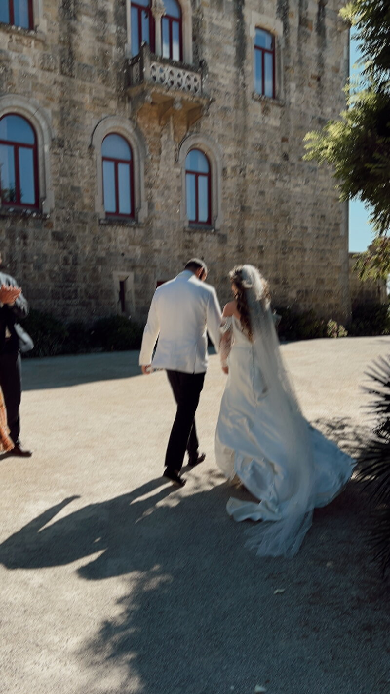A newlywed couple outside their venue with their backs to the camera